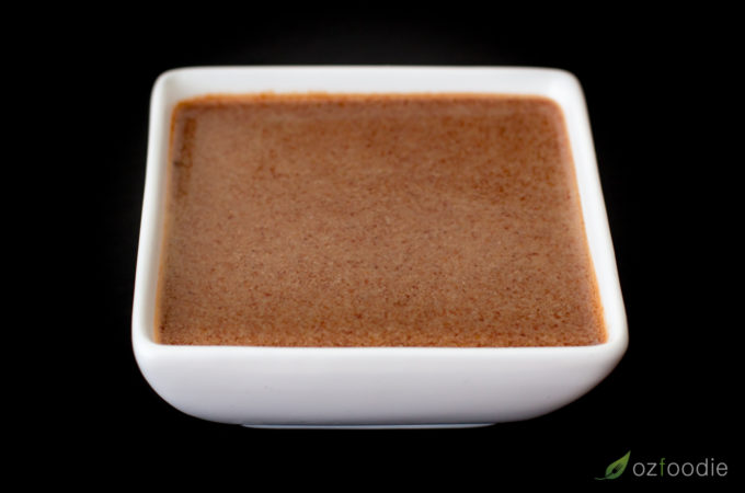 Hoisin sauce in a small square white bowl.