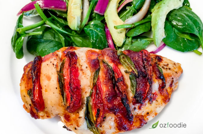 Hasselback Caprese Chicken with a fresh garden salad on a white plate